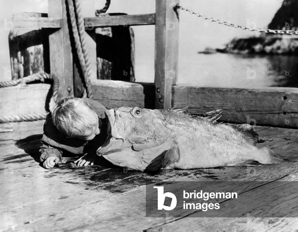 Young fisherman with his prize catch. December 1937