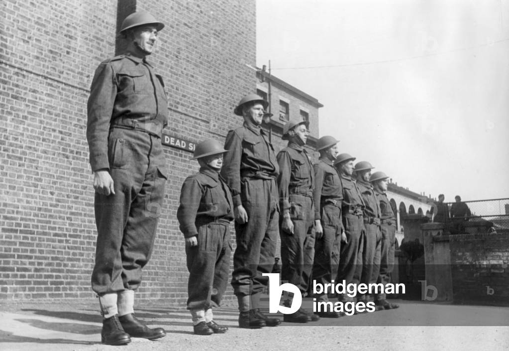 Frank Vincent, the smallest man in the army lines up with the taller members of his regiment during inspection in the Second World War April 1941 (b/w photo)