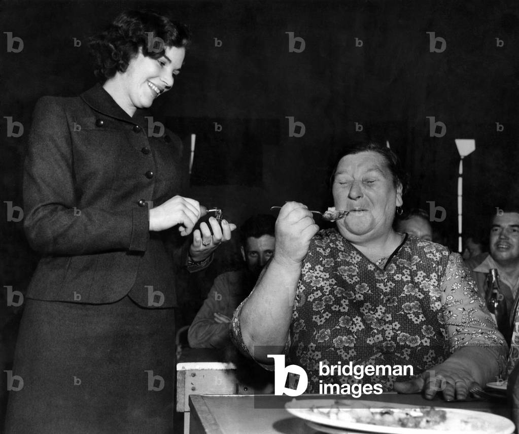 Woman eating dinner in the canteen at a labour factory. August 1952