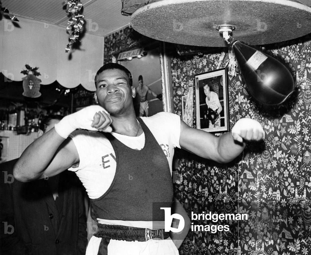 Nino Valdes at work on the Punchball during a training session at Toby's gym off the Old Kent Road. November 1956 (b/w photo)