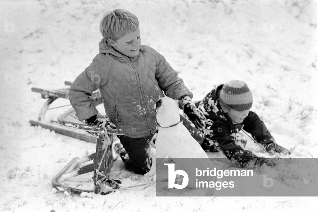 Weather snow scenes at Hampstead Heath. Winter: A spill at the bottom of the toboggan run which ended in all smiles and laughter, then up to the top again. November 1969