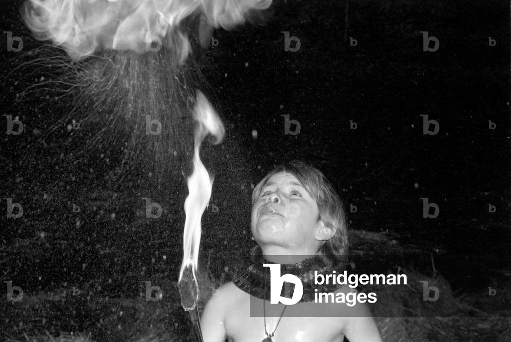 9 year old fire eater Tony Walls. Tony spitting a ball of flame, December 1976 (b/w photo)