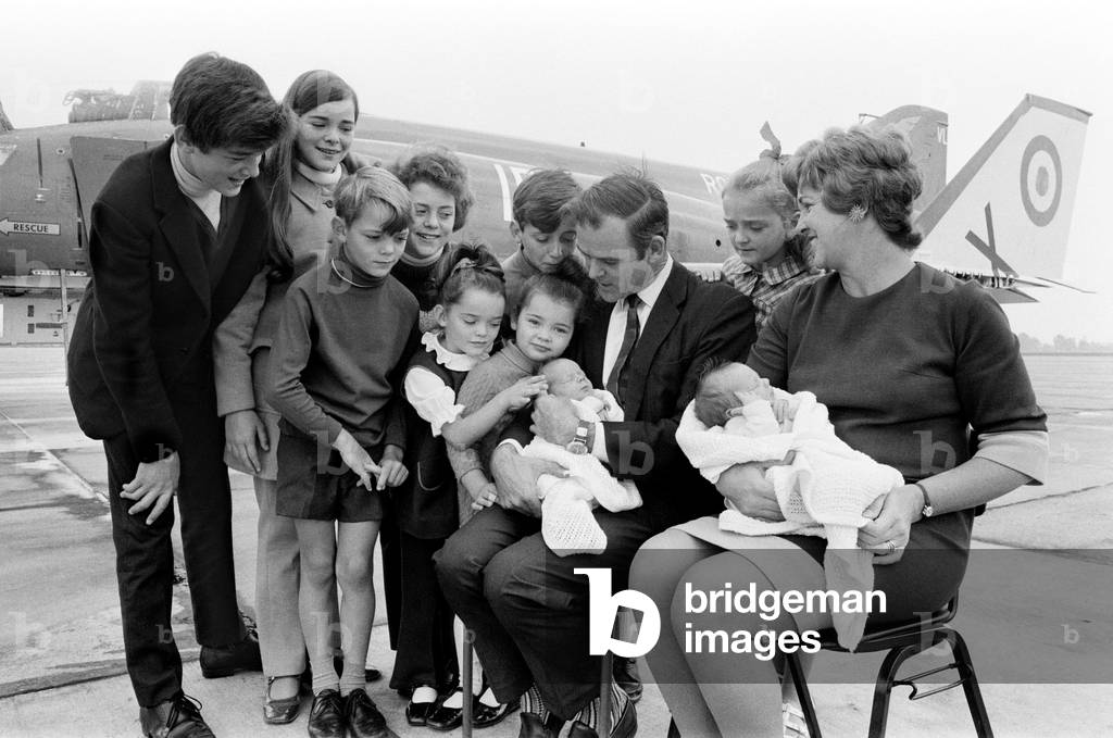 Lieutenant Commander Peter Marshall of HMS Ark Royal and his wife Carolyn, both holding their new born baby twin boys Paul and Mark, pose with their other eight children Kathryn, Ginny, Richard, Melanie, Sally, Carl, Kirstie and Christopher. 24th August 1971 (b/w photo)