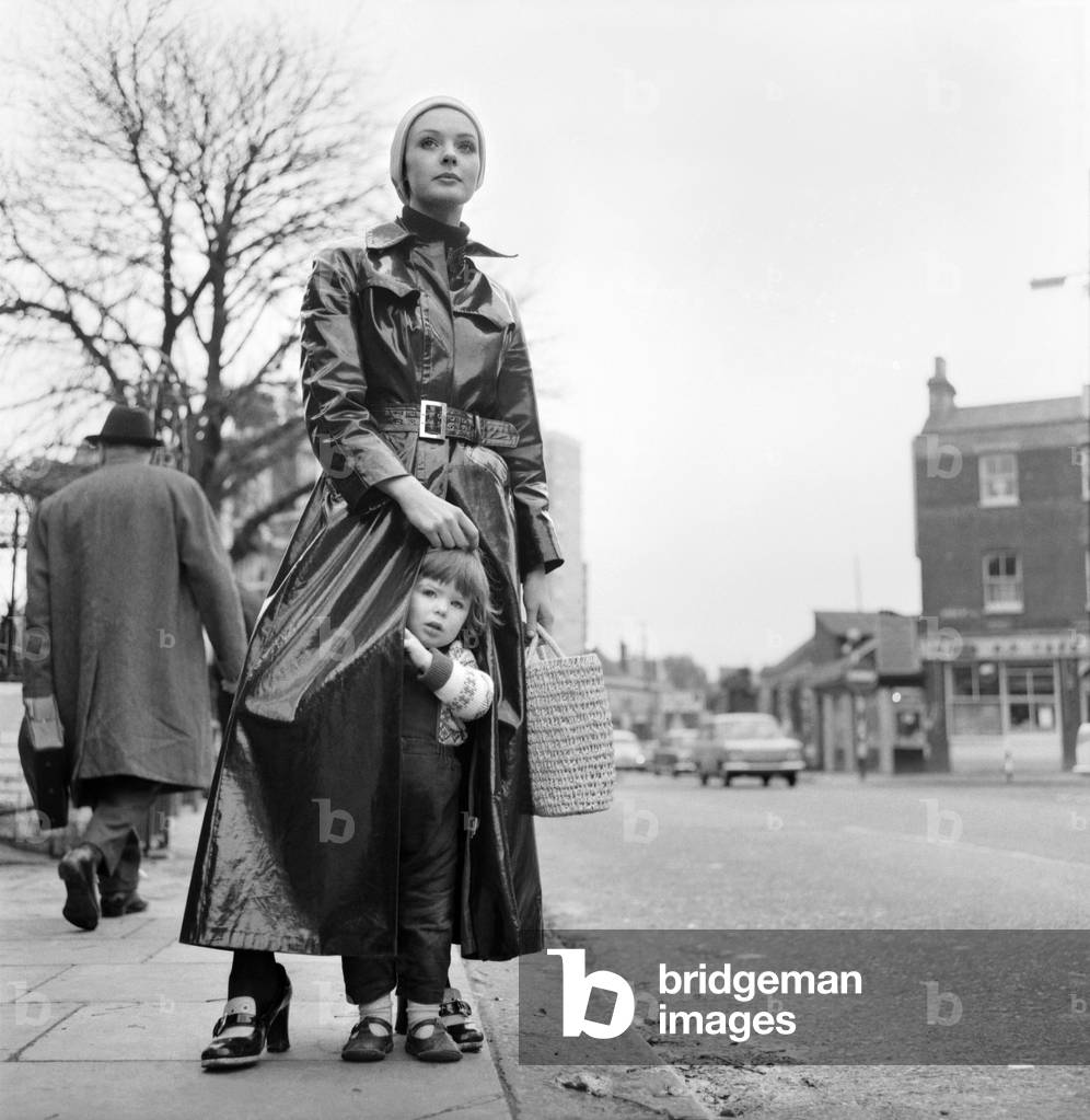 First day of real winter weather - and model mum Jane O'Leary with her 2 year old son Shane in Hampstead today keeping warm inside her maxi coat. 
November 1969