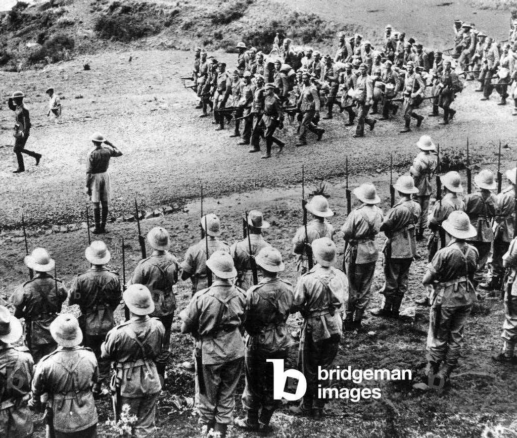 The Battle of Amba Alagi, the last Italian stronghold in Eritrea. OPS Italian Prisoners being marched from the front past South African troops, who are saluting them, 28th June 1940 (b/w photo)