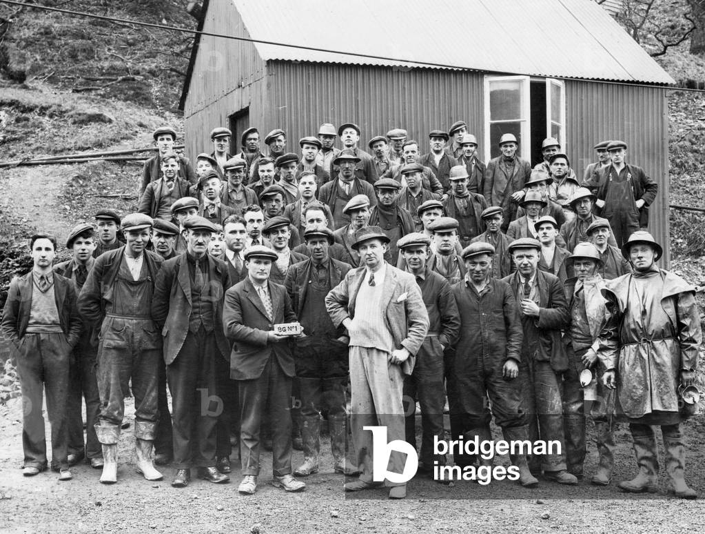 The first bar of gold at Dolaucothi Gold Mine with day shift workers. Afternoon and night shifts are also being worked. February 1938.