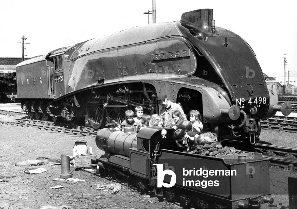 Engine No.4498 the Sir Nigel Gresley next to a small gauge steam train which seems more interesting to this group of children on 12th May 1977