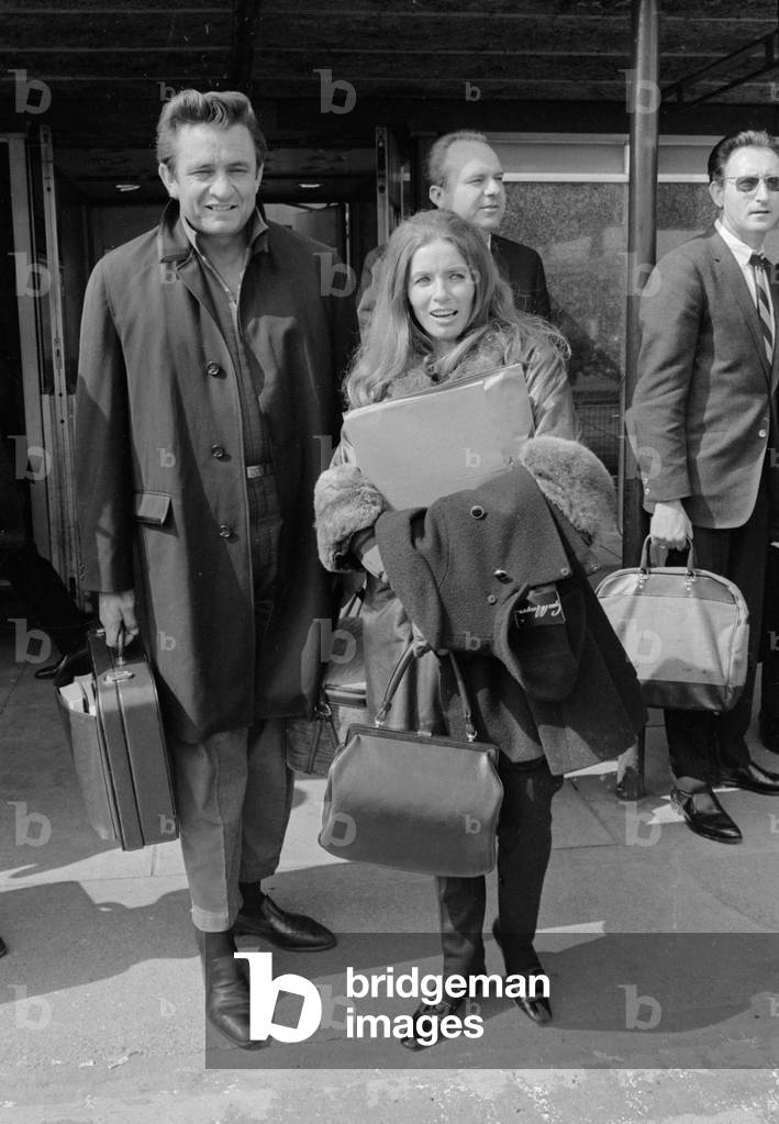 American country singer Johnny Cash with his wife June Carter arriving at Heathrow Airport from New York. 2nd May 1968 (b/w photo)