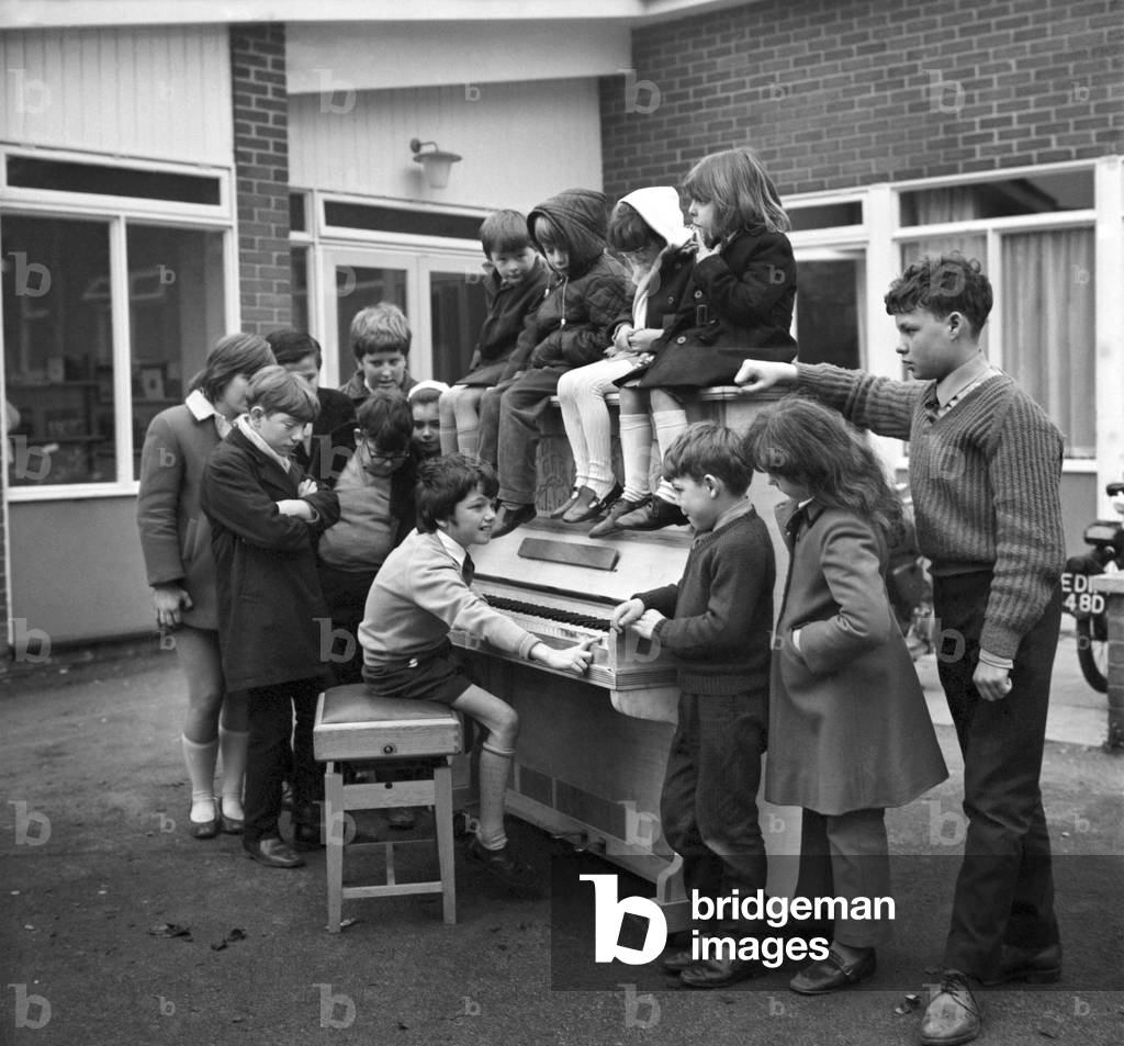 Eleven year old Martin Hawes entertains his school friends to a tune on the John Lennon piano which the Beatle gave to Braybrook School, Bracknell (Berks). January 1971