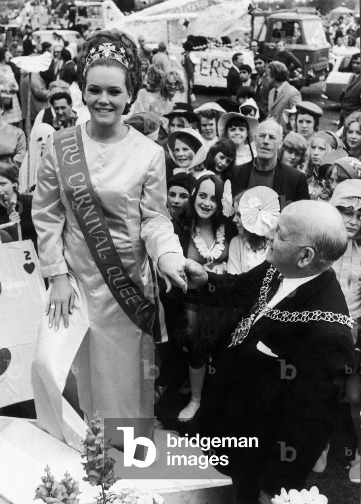 The Lord Mayor of Coventry, Alderman Tom Meffen, helps the carnival queen, Miss Heather Kinnie on to her float to head the Coventry Carnival procession out of Memorial Park. 14th June 1971 (b/w photo)