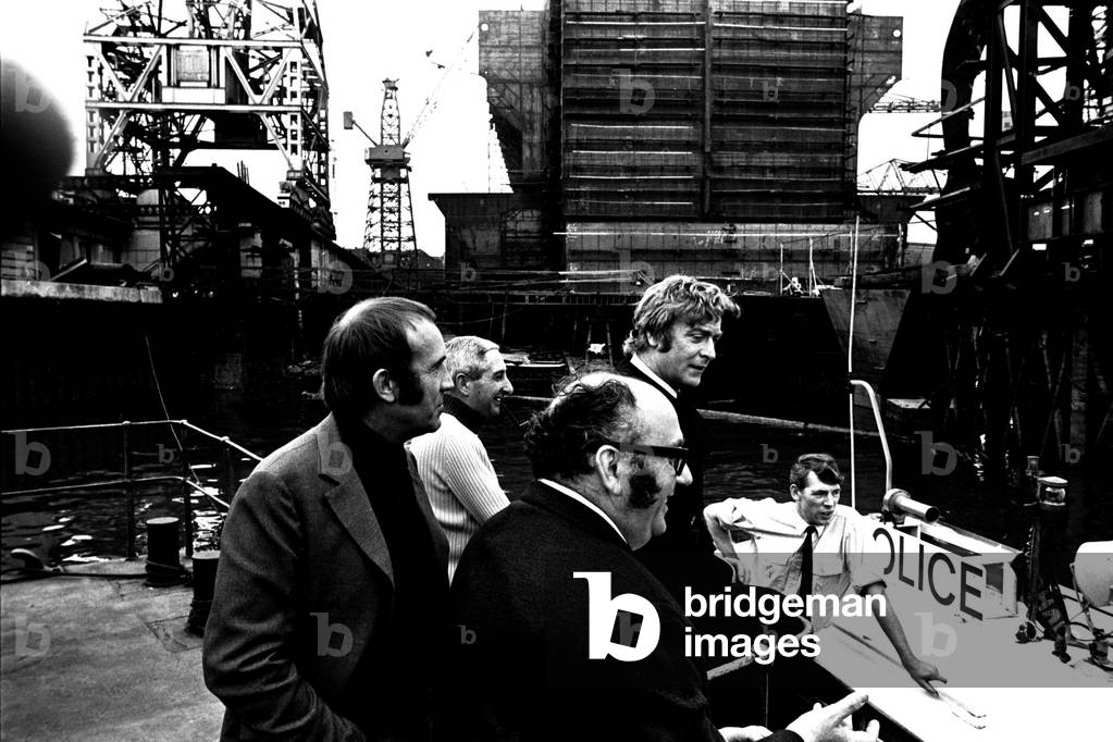 Michael Caine in a scene from the film Get Carter. Hebburn-Wallsend ferry landing with fellow actor Ian Hendry on 1st June 1970 (b/w photo)
