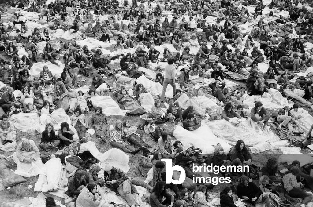 Reading Pop Festival. A group of fans listening to a group on stage at the main stage, with their plastic sheets ready to protect them from the rain, 26th June 1971 (b/w photo)