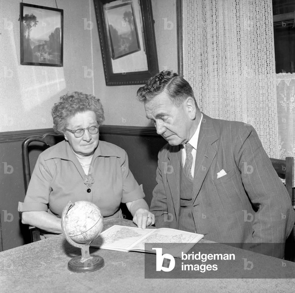 Holidays: Pensioners seen here looking at the globe deciding where to go to for their holidays Mr. and Mrs. Taylor, 1957 (b/w photo)