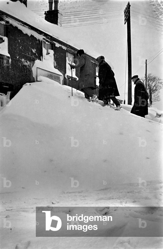 Tunnels to front door of a house, covereed by snow in the Peak District, Derbyshire. February 1947 O6548