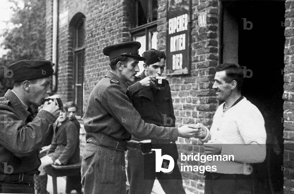 On the German border, war correspondent Rex North buys a drink for the road at the last pub in France before crossing the frontier during the Second World War September 1944 (b/w photo)