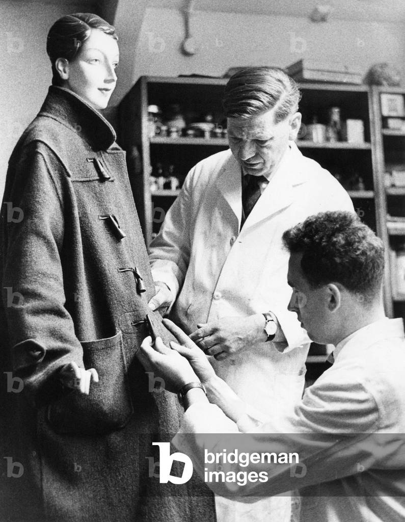 A police forensic laboratory - Mr Lee and Mr Haisman examine a stab wound in a coat on a dummy, c.1960