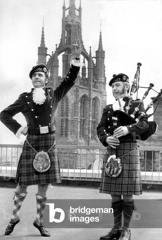Highland dancer Dick Harrison and piper Bill Hughes having a last practice before they set off to take part in an international festival in Austria in 9th May 1974 (b/w photo)