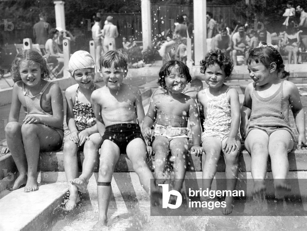 Children cool their feet in the paddling pool at Roehampton, 2nd July 1949 (b/w photo)