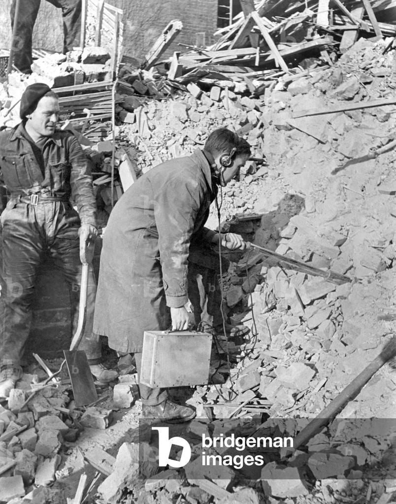 World War II: Hospital. Divining for Radium among the wreckage of what was the Marie Curie Hospital, Hampstead. Mr. E.E. Smith of the N.P.L. using an instrument known as the 