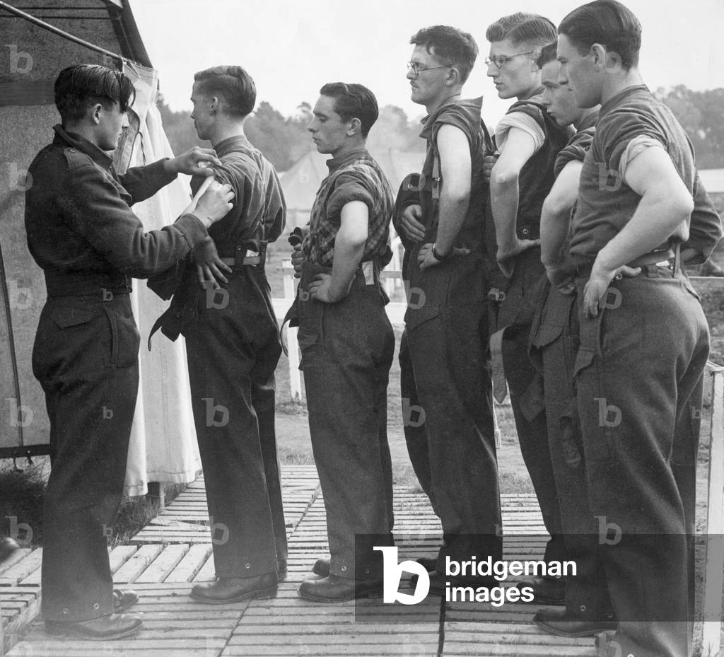 New army recruits wait in line with their sleeves rolled up as they wait to be vaccinated before being sent off overseas to fight in the Second World War
 October 1939