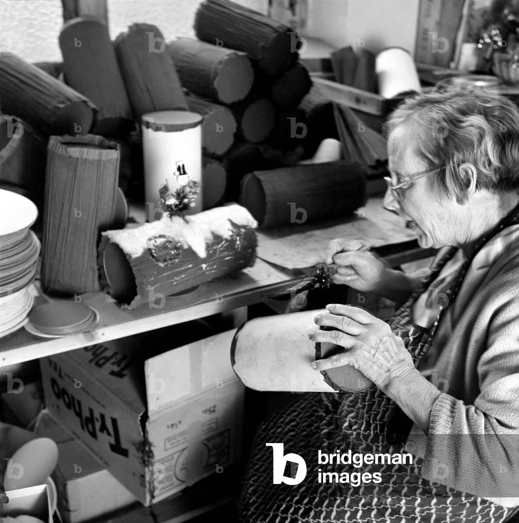 General scene in and around a Christmas cracker factory, where women construct and quality control the manufacture of the crackers, c. 1955 (b/w photo)