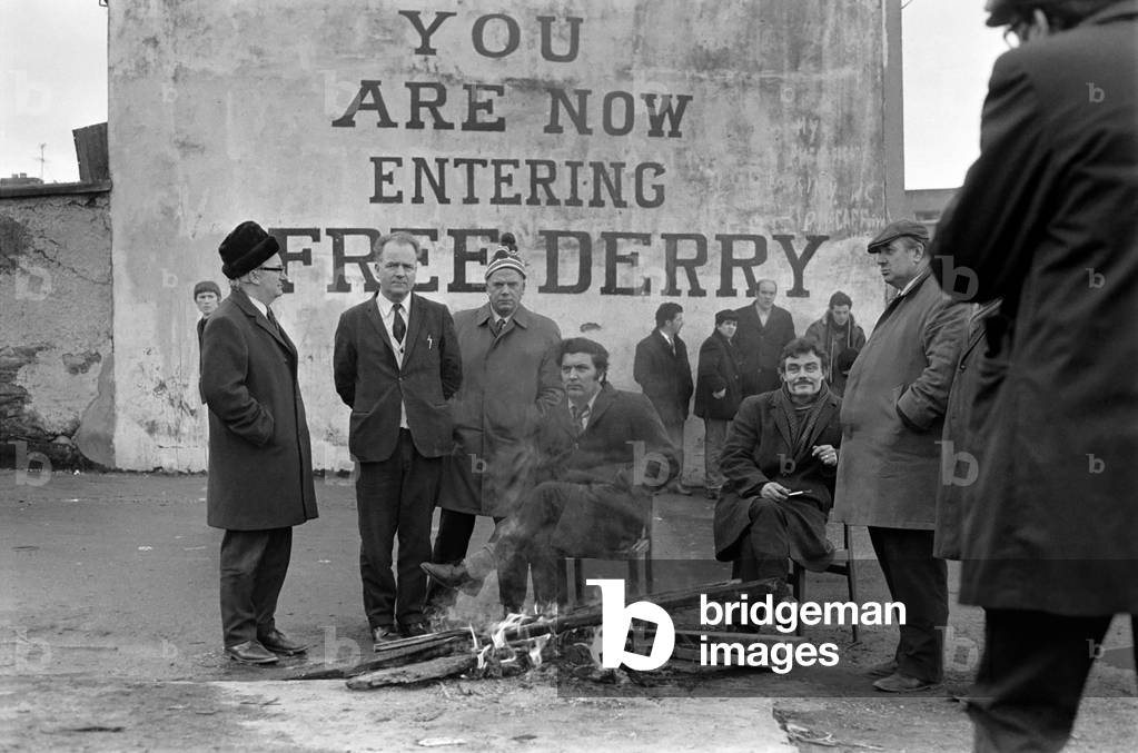 John Hume sits by fire in an early morning demonstration in Derry, Northern Ireland.
