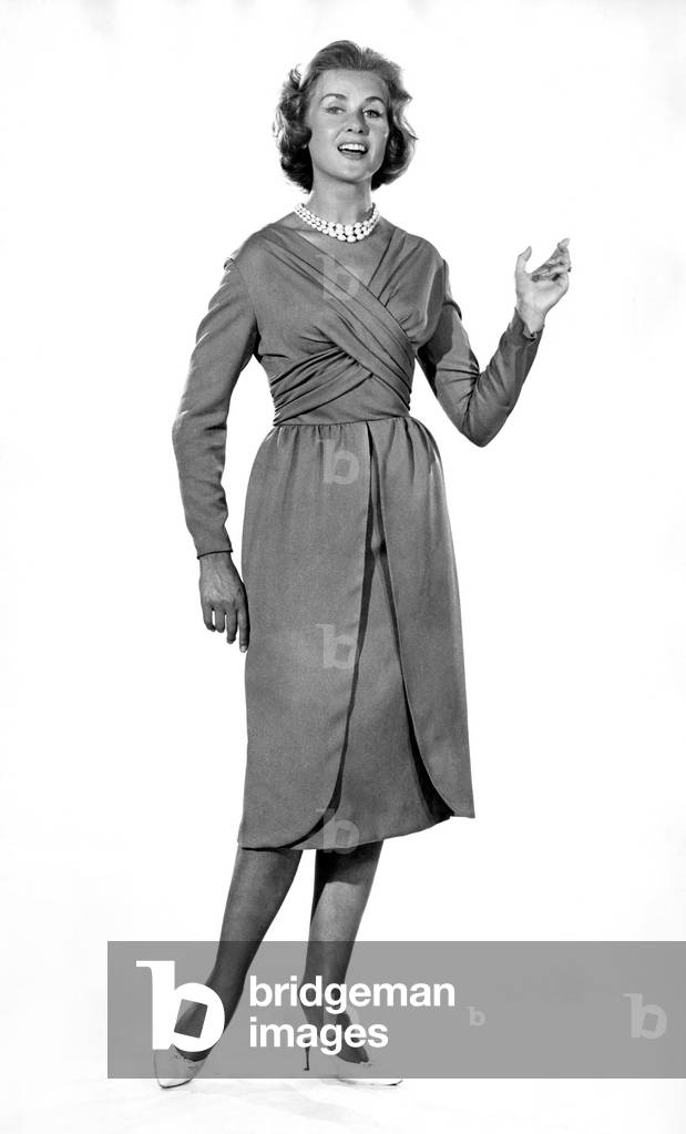 Reveille Fashions: Rosemary Steward modelling the latest 1959 design cocktail dress, November 1959 (b/w photo)