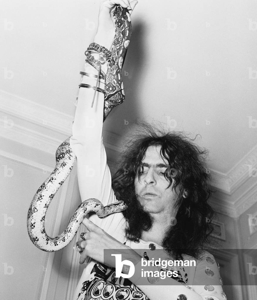 American rock singer Alice Cooper poses with his snake in London on his Love It To Death Tour, 12th November 1971 (b/w photo)