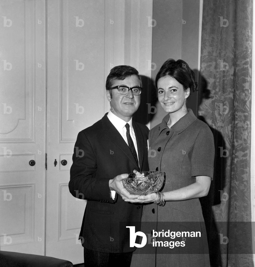 The engagement of Dr. Dickson Mabon, Minister of State Scottish Office, and Miss Elizabeth Zinn, General Manager of Westby and Co. Ltd., who cater for West End theatres. Dr. Dickson Mabon and his fiancé with the glass bowl presented by colleagues, October 1969 (b/w photo)