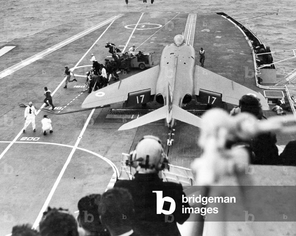 A supermarine Scimitar is manoeuvred on to the starboard catapult ready for take off on the deck of HMS Centaur, during a farewell exercise by the Fleet squadron. Liverpool, Merseyside, 19th August 1965.