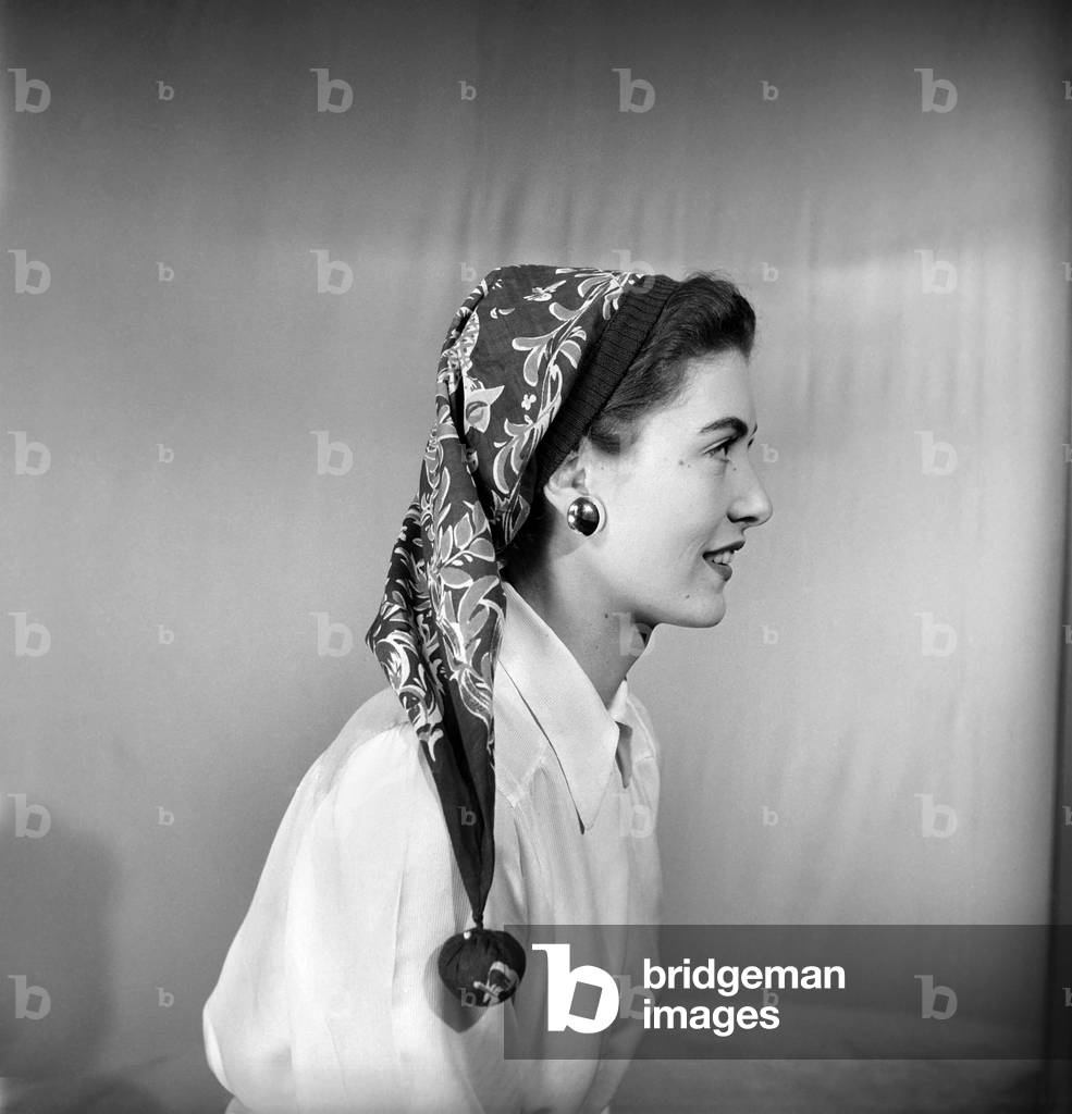 Woman modelling several ways of wearing a head scarf, April 1953 (b/w photo)