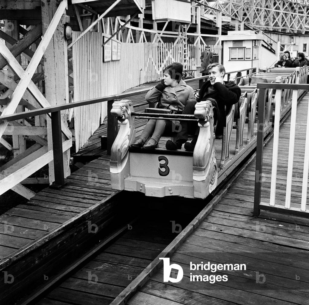 Scenes in Margate, Kent, during Good Friday. A couple on a funfair ride. 27th March 1964 (b/w photo)