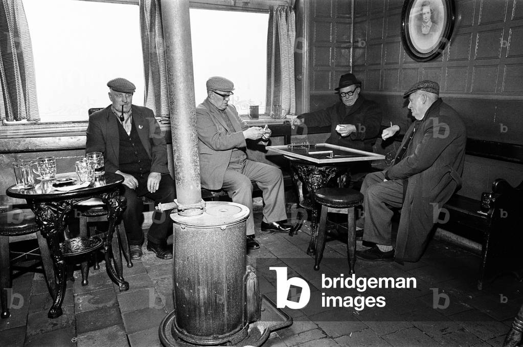 Group of men play dominoes at the Druids Head Inn in Coseley, a suburban area in the north of the Dudley, The Black Country, an area of the West Midlands in England, north and west of Birmingham. 25th May 1968 (b/w photo)