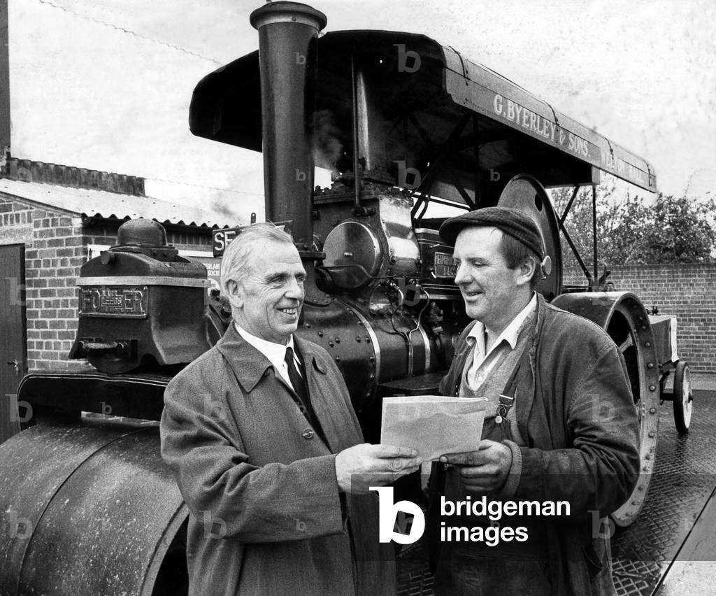 William Marshall, division inspector for weights and measure, Hexham gives George Ryerley, of Walton Hall, Stamfordham an envelope with the weight of his steam roller Highland Lass on 2nd June 1972 (b/w photo)