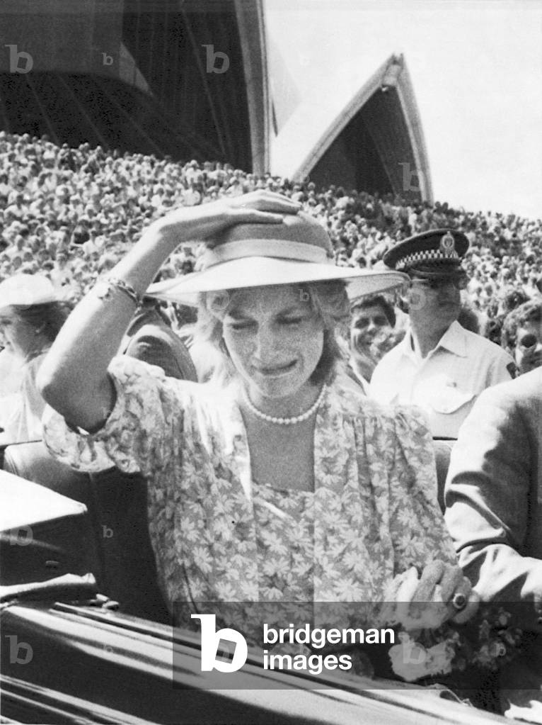 The Princess of Wales pulls a funny face as a bouquet of flowers hits her on the head when thrown from the crowd into the car. Sydney Opera House, Sydney, Australia, 28th March 1983