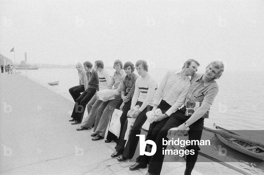 Leeds United players sit on a railing on the promenade as they take a walk around the town of Salonike prior to their 1973 European Cup Winners Cup Final match against AC Milan at the Kaftanzoglio Stadium in Thessaloniki, Greece. Leeds lost 0-1 in the Final following some controversial decisions by Greek referee Christos Michas. 15th May 1973 (b/w photo)