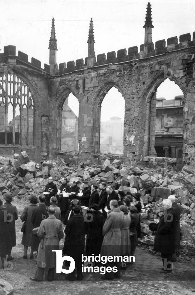 Crowds gather for a remembrance service inside the ruins of Coventry Cathedral, 15th November 1942 (b/w photo)