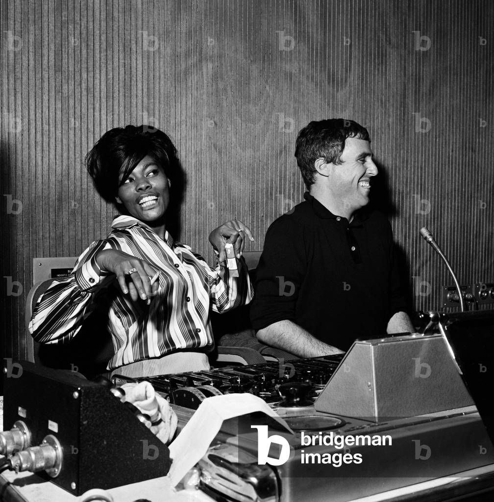 Burt Bacharach and Dionne Warwick recording a song at the Pye studios in London. At the control panels, a delighted Dionne and Burt listen to the recording. 29th November 1964 (b/w photo)