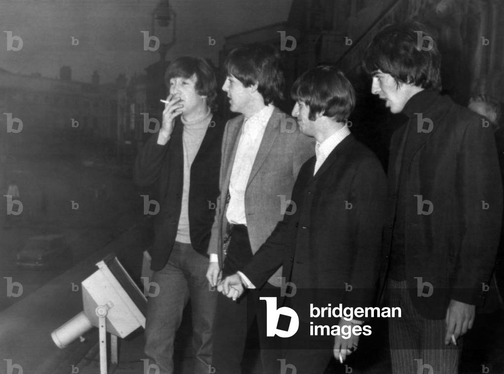 The Beatles enjoy a cigarette break on the balcony of the Empire Theatre in Liverpool 8th November 1964.