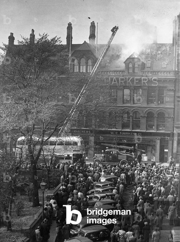 Crowds of spectators watch the fire at W E Harkers Furniture shop in Grainger Street, Newcastle, 1940