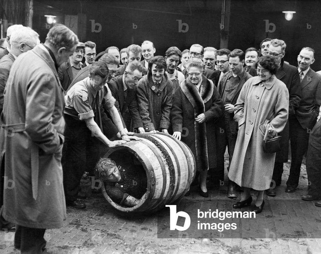 Anthony Renshaw, a Cooper's apprentice at Grove and Whitnall, brewers of Salford, had his passing out iniation in the brewery yard today, Weds: He is seen here starting a roll inside a barrel he had made, with the good wishes of the staff of the company. January 1960