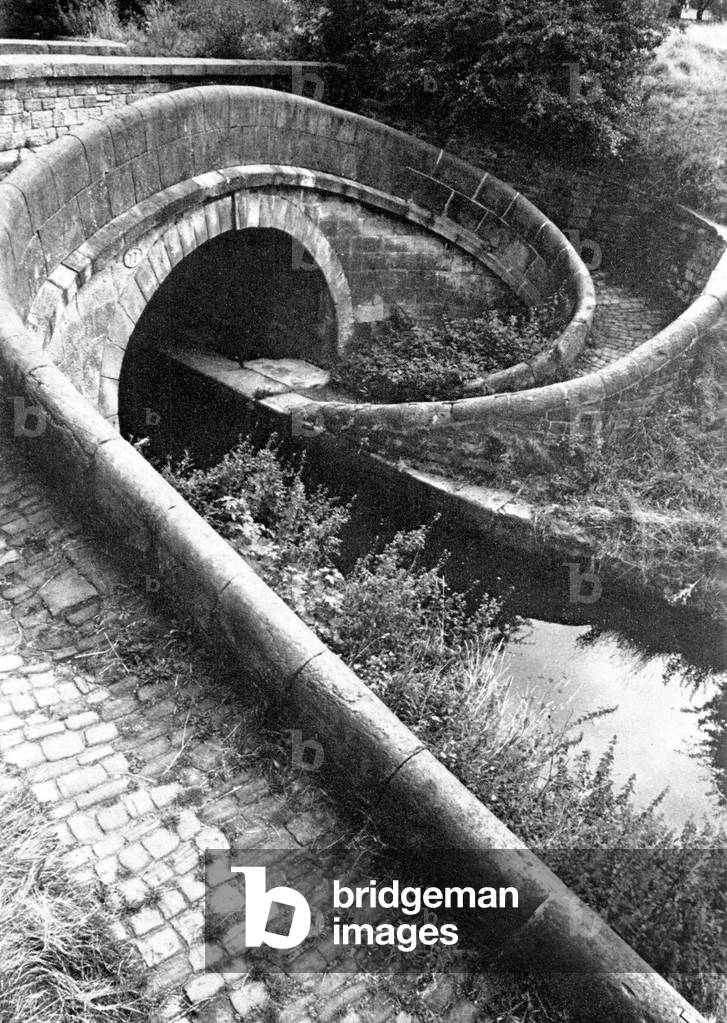 A Turnover bridge, designed to take the towpath from one oside of the canal to the other. It is a practical solution to a practical problem, but a supremely elegant one, c.1970
