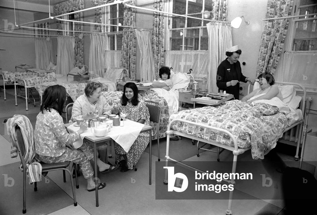 The Good Samaritans stand on parade in a hospital ward. They are some of the volunteers who stopped a small hospital from shutting down. They came to the rescue of matron Miss Queenie Graham after only two nurses turned up for duty. Most of her staff of 31 were victims of the flu epidemic which has hit Merseyside. But willing hands were ready when the call went out for helpers. Nearly 50 offers flooded the switchboard at the 50 bed Sir Alfred Jones Memorial Hospital, at Garston, Liverpool. December 1969