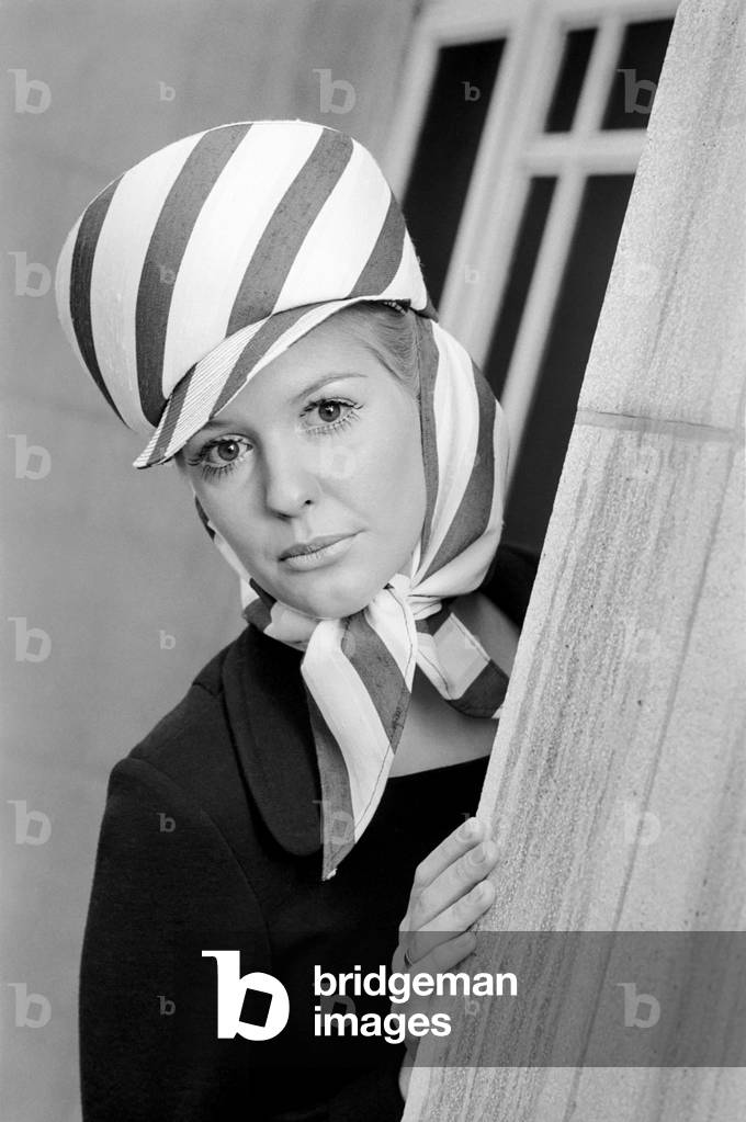The Millinery Guild showed their Spring Collection of hats at the Dorchester, London. Jane Whiteley wearing a sun hat - shades of the Foreign Legion in crisp navy and white stripes by Gina Davies. 
November 1969