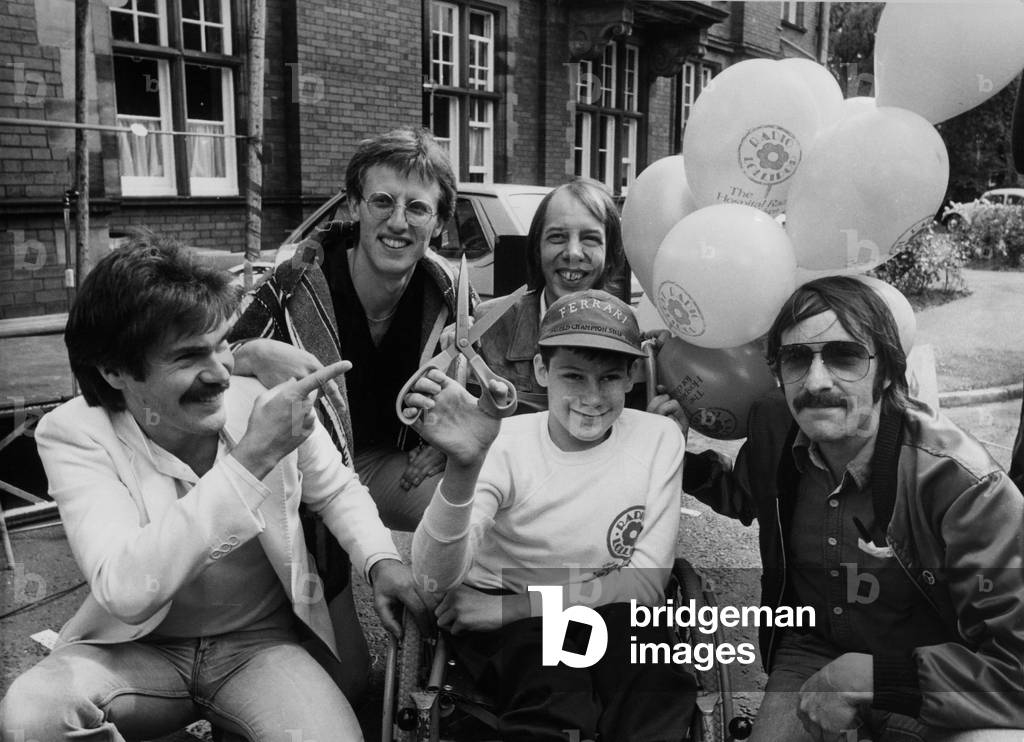 Disabled youngster Steven Graham officially launching Radio Lollipop at the Fleiming Memorial Hospital for Sick Children in Jesmond, Newcastle. Members of the Tyneside band Lindisfarne watched the opening (l, to, r) Ray Jackson, Ray Laidlaw, Rod Clements and Alan Hull. 23/08/82