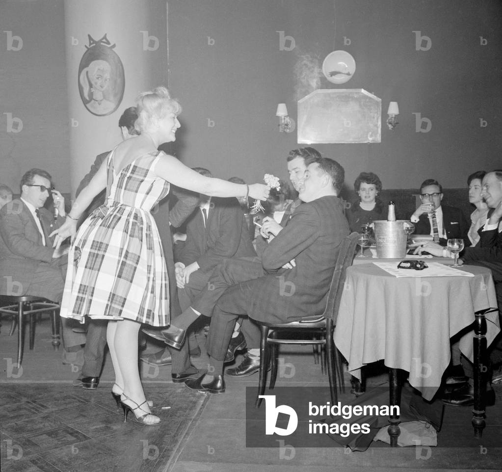 Monte Carlo Rally winner Paddy Hopkirk enjoys the attention of a hostess in a Monte Carlo nightclub as he celebrates his victory, 25th January 1964 (b/w photo)