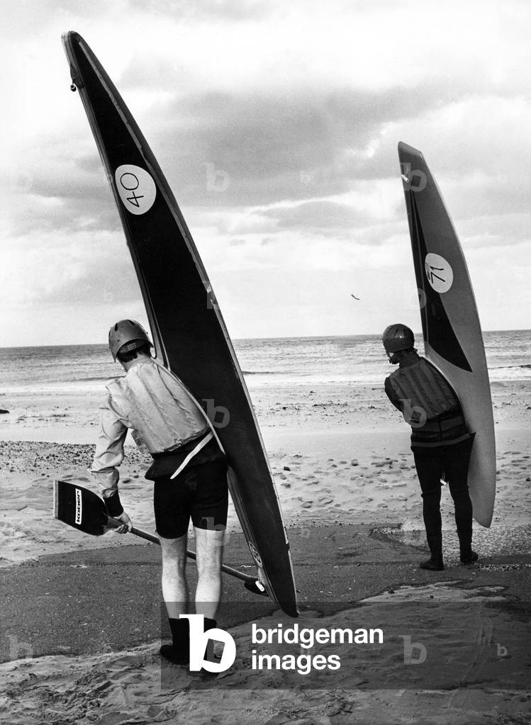 These surf canoeists don't seem to mind how miserable the weather is when it comes to their favourite pastime