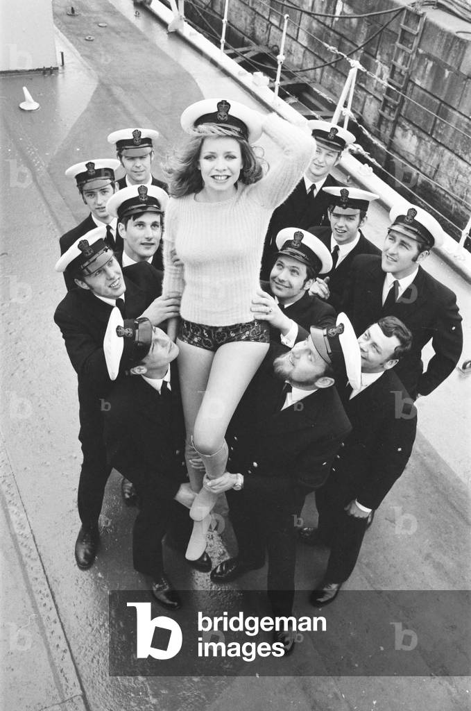 Daily Mirror, Hotpants Girl Josephine Howard 16 from Essex, with Apprentice Engineers from HMS Caledonia, who asked Josephine to be their 'pin-up'. Pictured at Rosyth in Fife Scotland, April 1971 (b/w photo)
