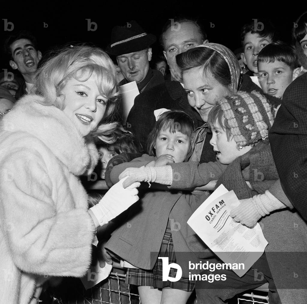 Celebrities including singer Kathy Kirby and Bruce Forsyth singing carols in Trafalgar Square, London, 22nd December 1963.