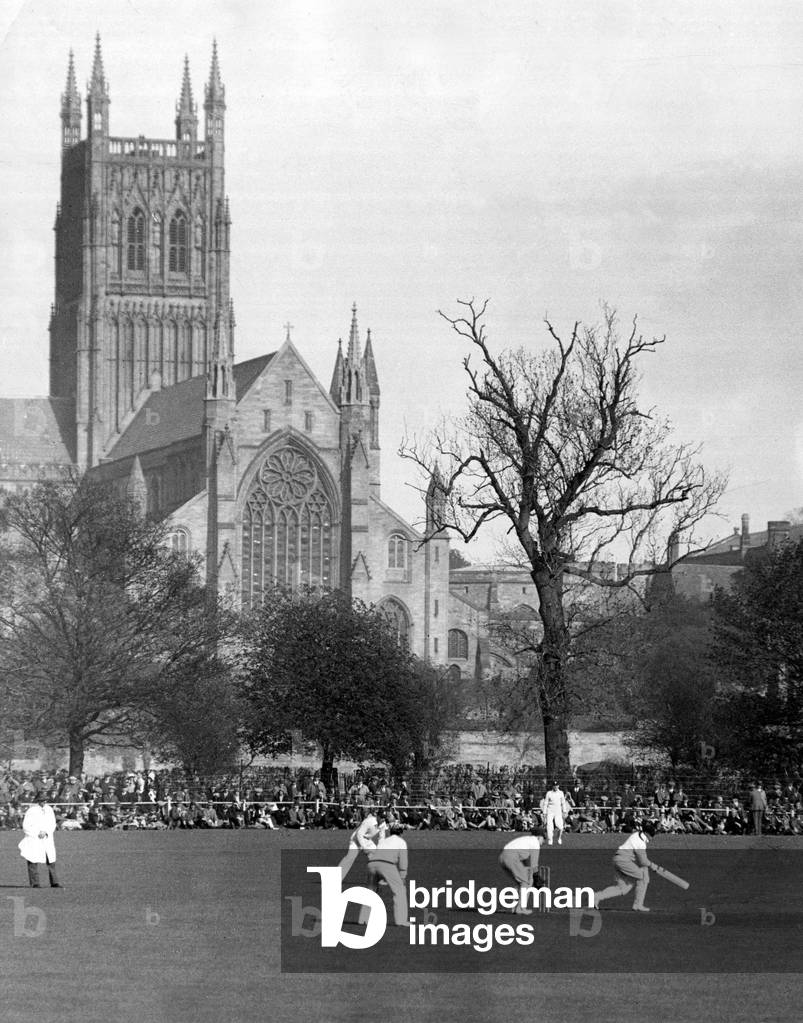 Worcester Cathedral Central Tower stands tall in the background, during cricket match against English County team Worcestershire and Australia at New Road, Worcester, England. Don Bradman batting for Australia, May 1930 (b/w photo)